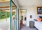 Waiheke Woodside Bay Chalet: master bedroom opening onto deck